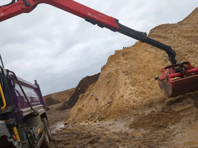 Grab lorry hydraulic arm loading soil on a Branksome area job