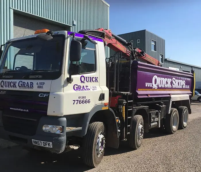 Quick Skips grab hire lorry loading waste on site in Branksome, Dorset